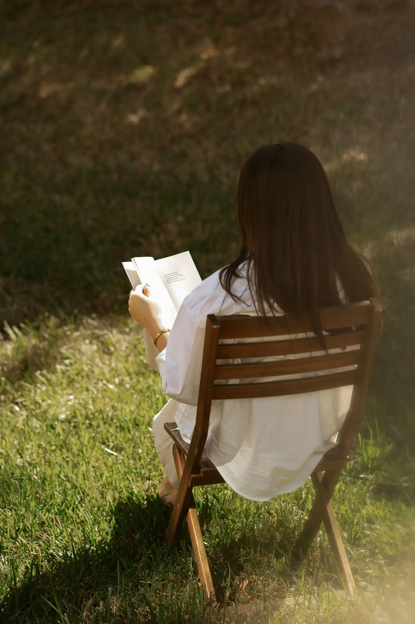 Dani Torres leyendo al aire libre, vista de espaldas.