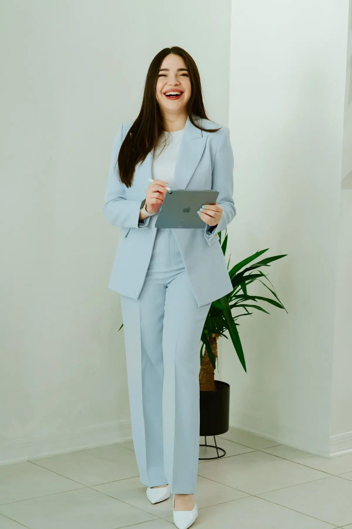 Dani Torres sonriendo, con traje azul y una tablet en sus manos